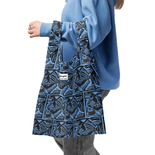 Person wearing a blue patterned apron with a brand label on a white background