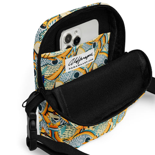 Multicolored patterned crossbody bag with a phone inside on a white background